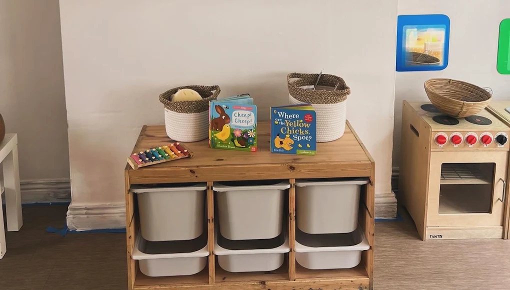 Baby room shelf with board books, baskets and a play kitchen
