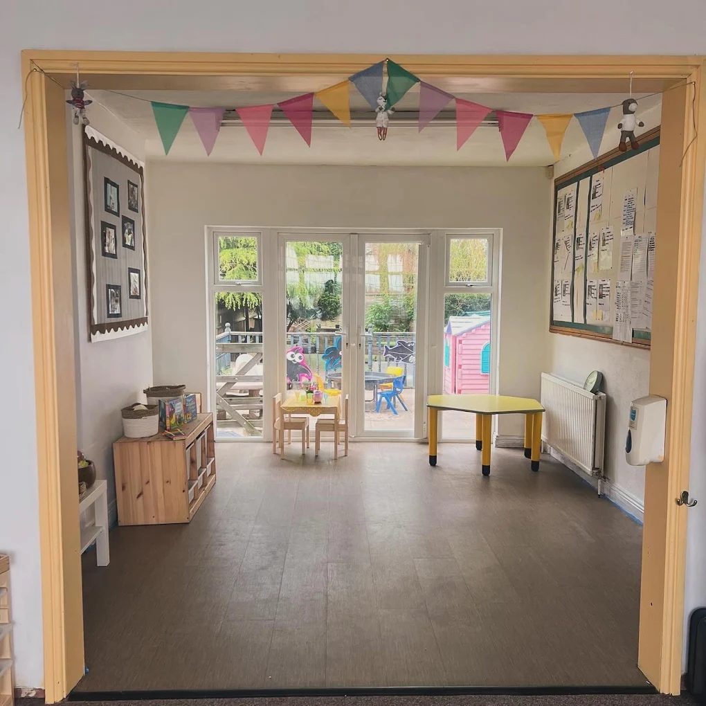 A bright room at The Lanes with bunting, opening onto the garden